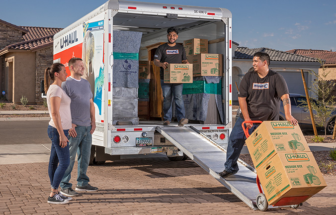 Moving Helpers loading boxes into a U-Haul moving truck